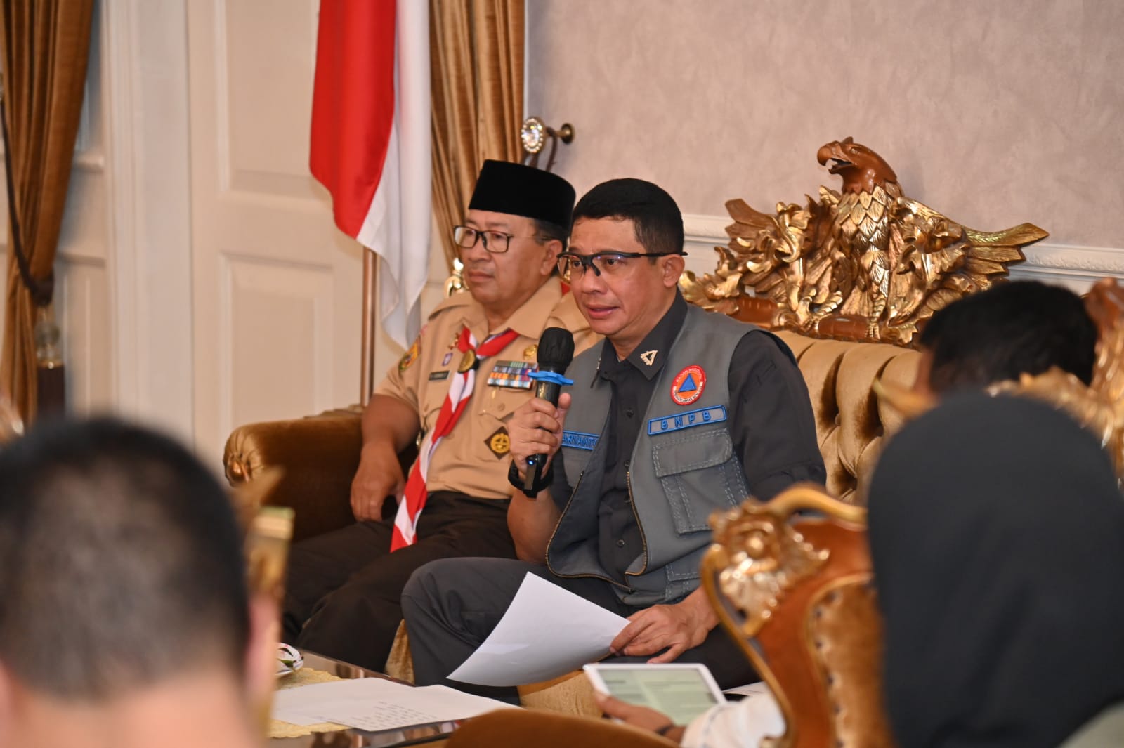 Kepala BNPB Letjen TNI Suharyanto (menggunakan rompi dan kemeja hijau) saat memimpin Rapat Evaluasi Percepatan Pelaksanaan Pembangunan Rumah Rusak bagi masyarakat terdampak gempa pada November yang lalu. Rapat ini dilaksanakan di Kantor Bupati Cianjur, Jawa Barat pada Jumat (14/7).